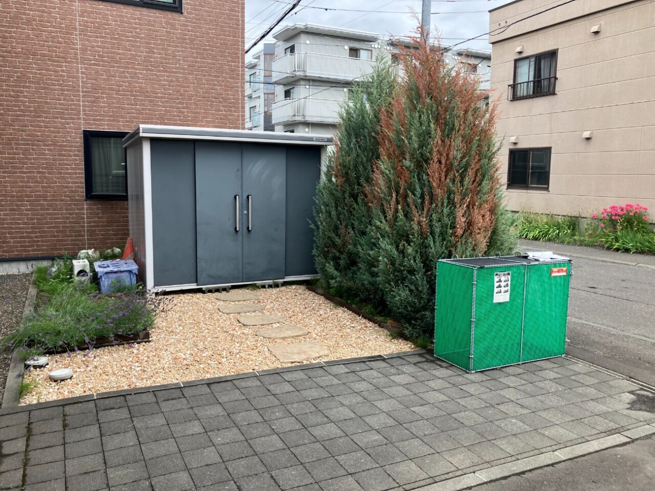 施工前は、アスファルト舗装されたスペースにカーポートが設置されていない状態でした。 設置予定箇所の周辺にはガーデンブロックがあり、そのままでは施工時に干渉するため、カーポートの位置や柱の設置箇所を確認しながら、必要な加工や取り外しを行う計画としました。