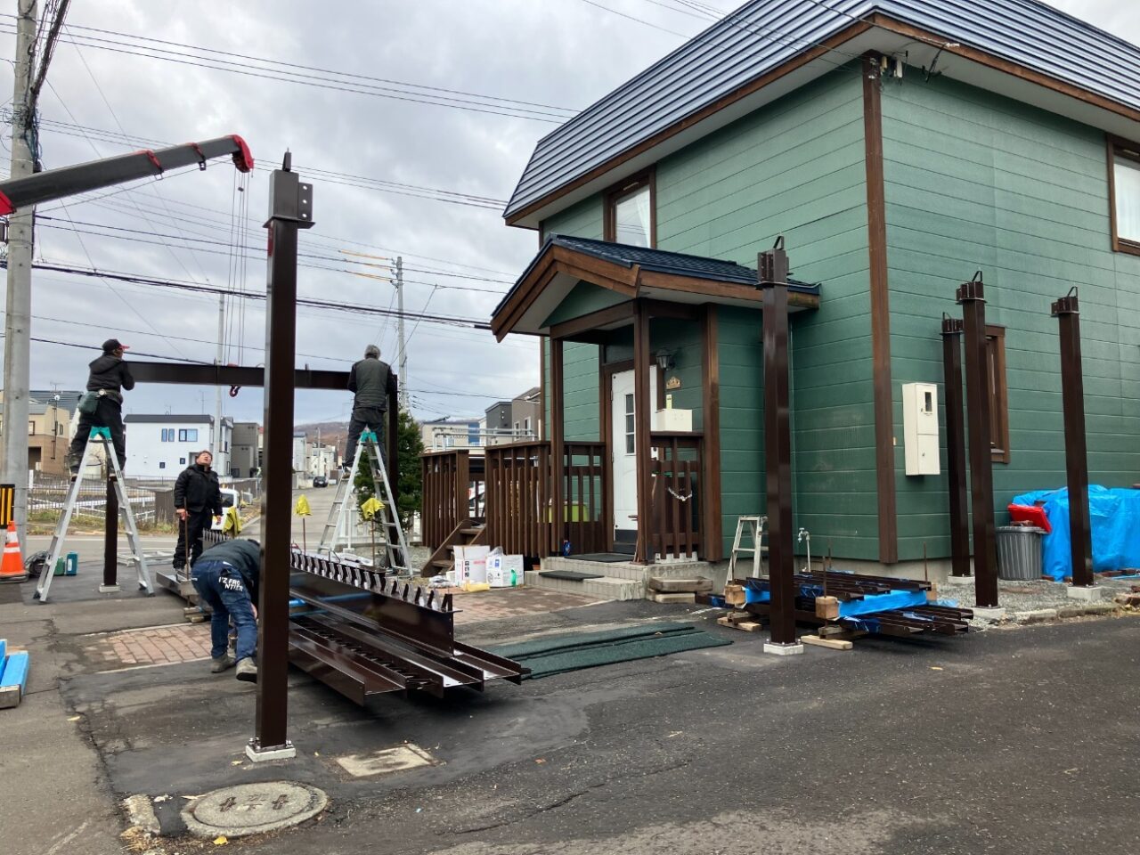 既存の庭部分を整理し、駐車スペースとして活用できるよう地面を整えていきます。あわせて、これまで使用していた1台用カーポートを撤去し、新しいカーポートを設置するためのスペースを確保しました。 その後、特別注文の鉄骨3台用カーポート「AP760L型」を設置していきます。柱や梁を組み上げながらカーポート全体を施工し、3台分の車を駐車できる屋根付きスペースを整えました。 カーポートの設置にあわせて、敷地境界には既存と同様にアルミフェンスを設置しています。庭だった部分まで駐車スペースとして活用できるよう、外構全体を整えていきました。